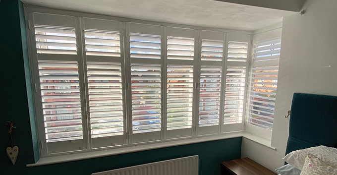a row of shutters installed on a bedroom window