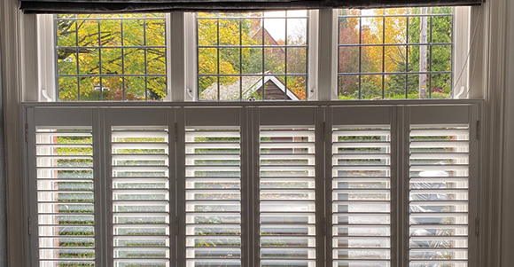 cafe style shutters installed on two thirds up a window 