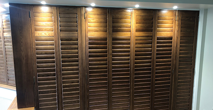 track shutters installed as wardrobe doors in a room