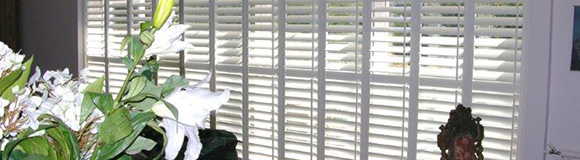 closed track shutters installed onto a window of a sitting room