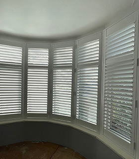 curved shutters on a window installed at full height